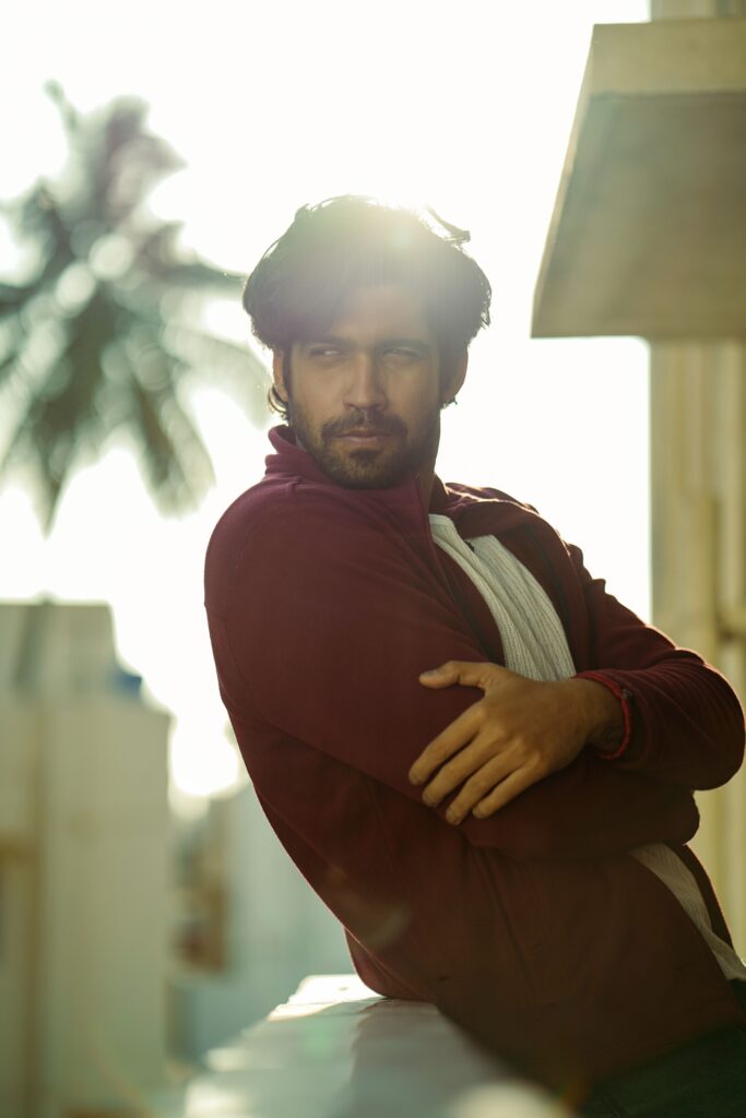 Casual young man in sunlight with soft focus cityscape background.